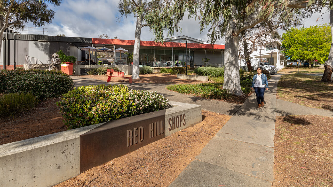 A young woman walking past Red Hill Shops