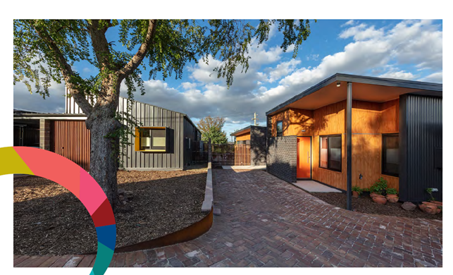 A granny flat and an existing residence with a pathway separating them.